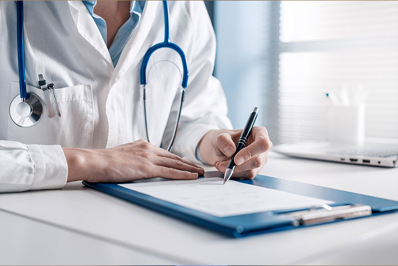 Stock image of doctor guided in signing medical forms